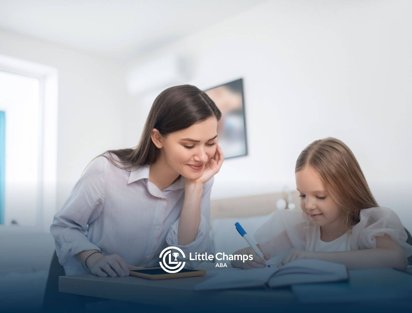 BCBA watching girl write in a notebook at desk in ABA therapy.