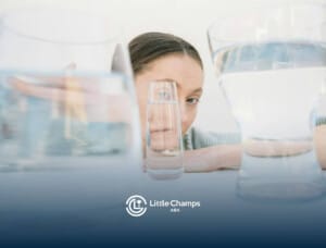 Autistic woman looking through glasses of water with a distorted reflection on a table in Utah after ABA therapy.