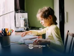Girl with autism concentrating at a table while organizing colored pencils and drawing materials.