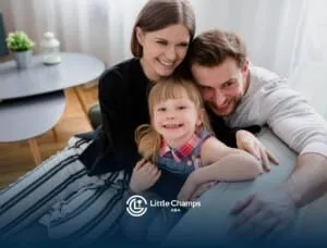 A smiling family sitting on a couch, hugging and enjoying time together.