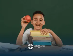 Smiling boy with autism holding an apple and books at a study desk