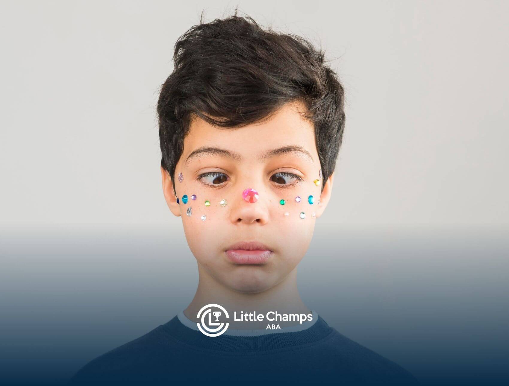 A boy with colorful rhinestones adorning his face, gazes curiously to the side, his expression full of wonder and intrigue.