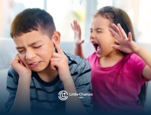 A frustrated child pulling their hair in distress, expressing strong emotion while sitting in a neutral setting.