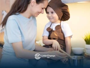 A mother and her autistic son, both smiling, as they cook together in the kitchen with a playful atmosphere.