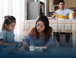 A female ABA therapist and her young autistic child sitting at a table, drawing together in a cozy, well-lit home.