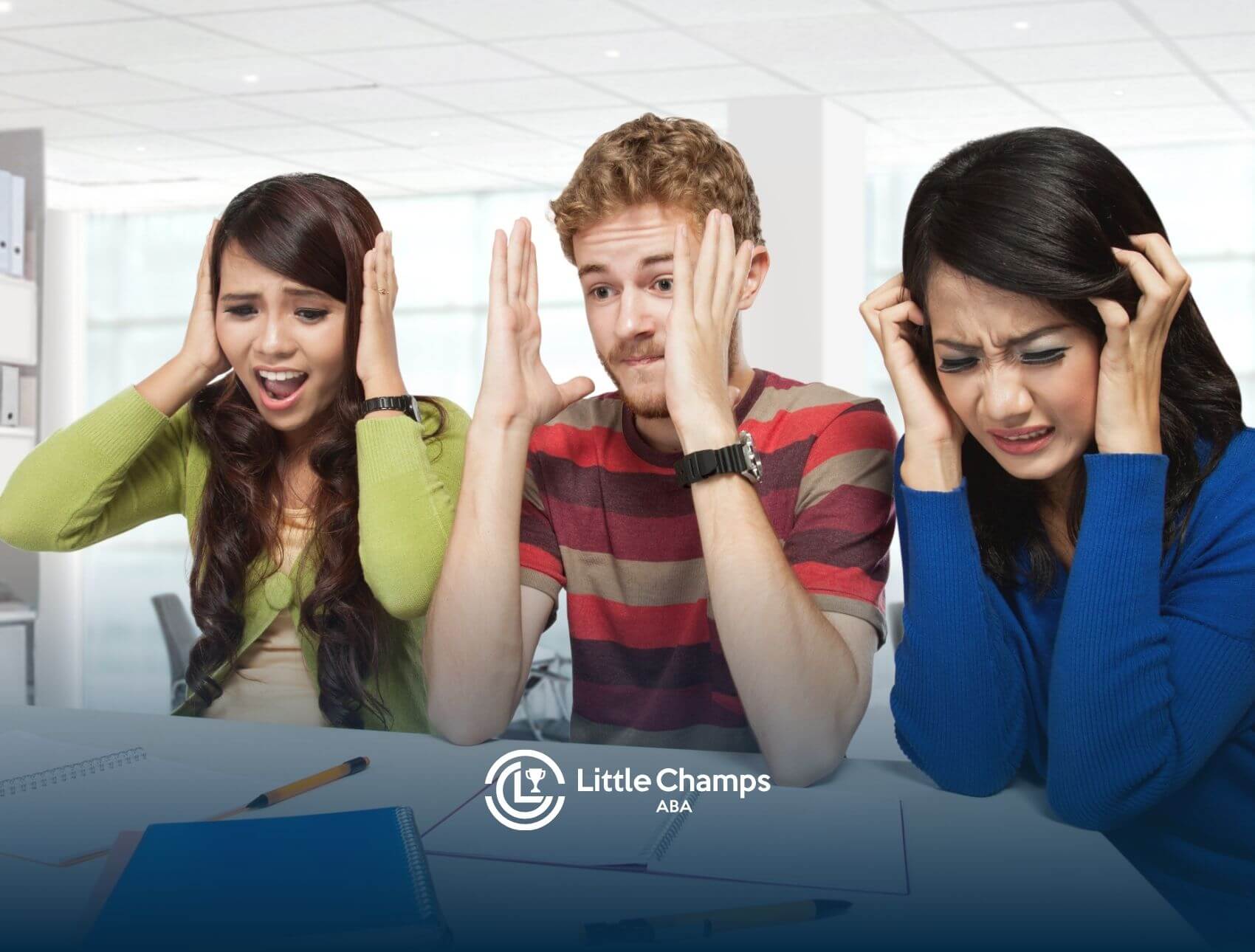 Three ABA students in an office space, all holding their heads and looking stressed or overwhelmed after the exam.