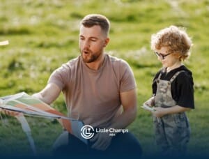 BCBA helping a smiling young child with autism fly a colorful kite in a grassy park.