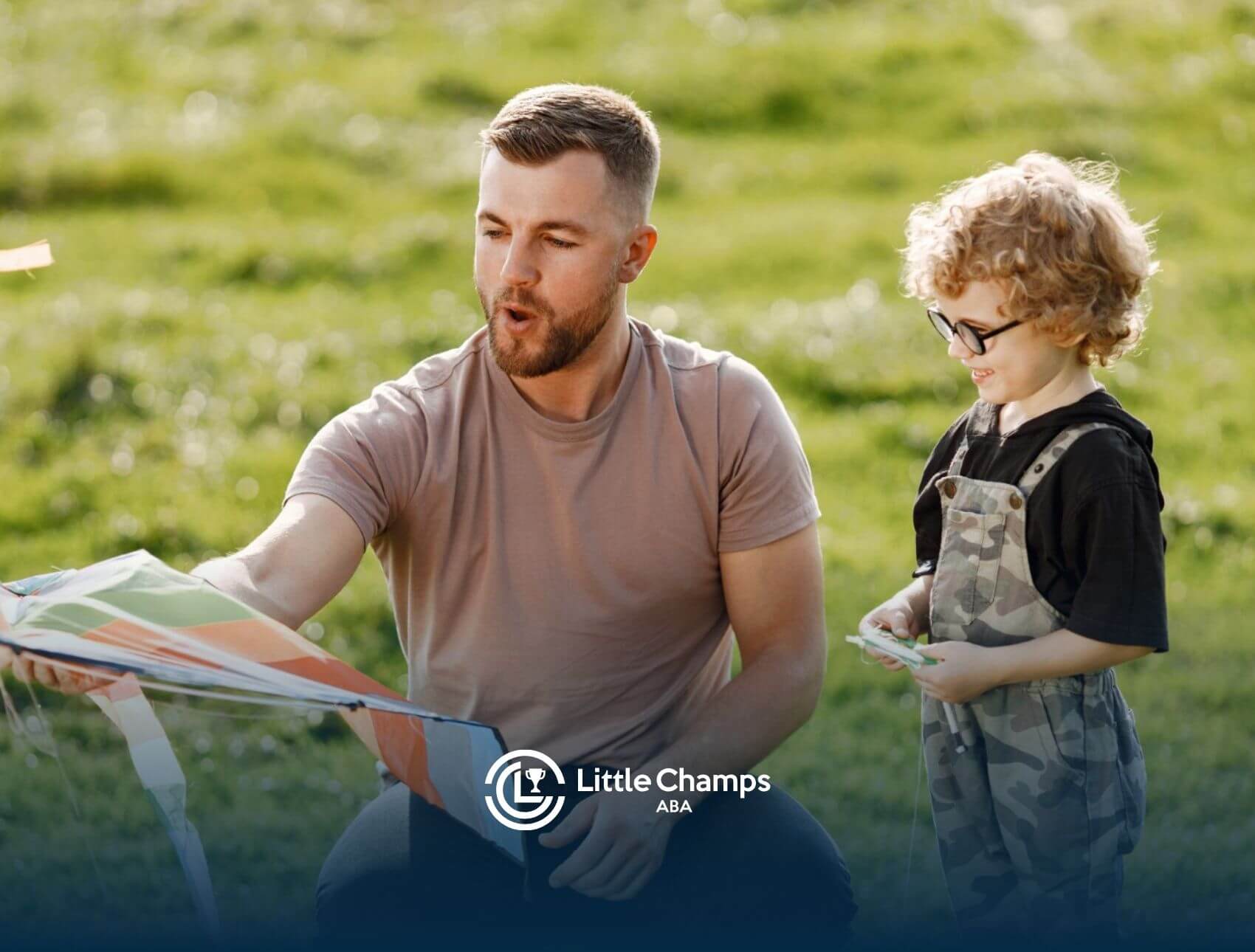 BCBA helping a smiling young child with autism fly a colorful kite in a grassy park.