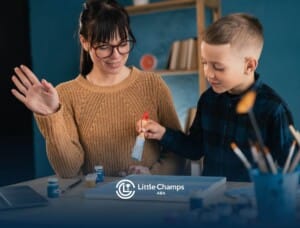 BCBA guiding a child during a painting activity in an ABA therapy session.