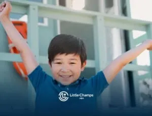 Happy young boy smiling with arms raised, possibly celebrating progress during ABA therapy session.