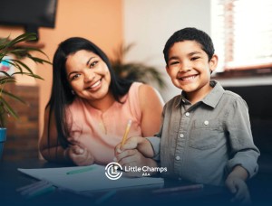 Smiling BCBA and young boy sitting at a table in ABA therapy.