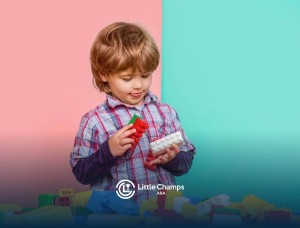 Child playing with colorful building blocks against pastel background in ABA therapy.