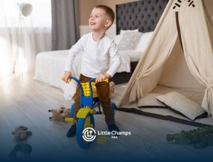 Young boy riding a small tricycle in a bedroom with toys on the floor.