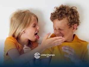 Two children with autism in yellow shirts, one playfully sticking out their tongue while the other reacts.