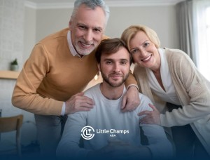 Adult man sitting with his parents standing behind him, smiling at the camera.