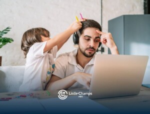 BCBA working on laptop while child playfully puts pencils in his hair.