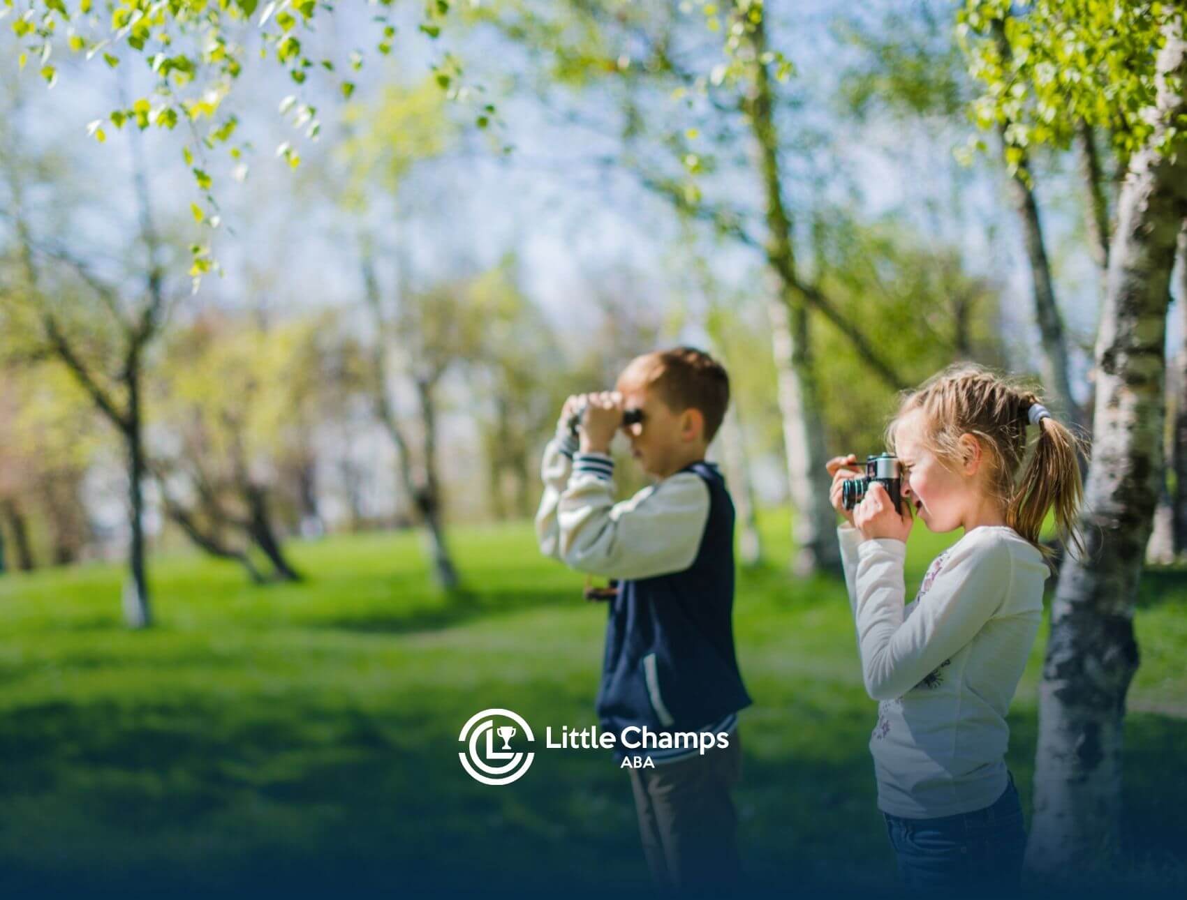 Two children with autism exploring nature with binoculars in a quiet park setting.