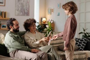 Child practicing social skills with parents during an ABA therapy activity at home.