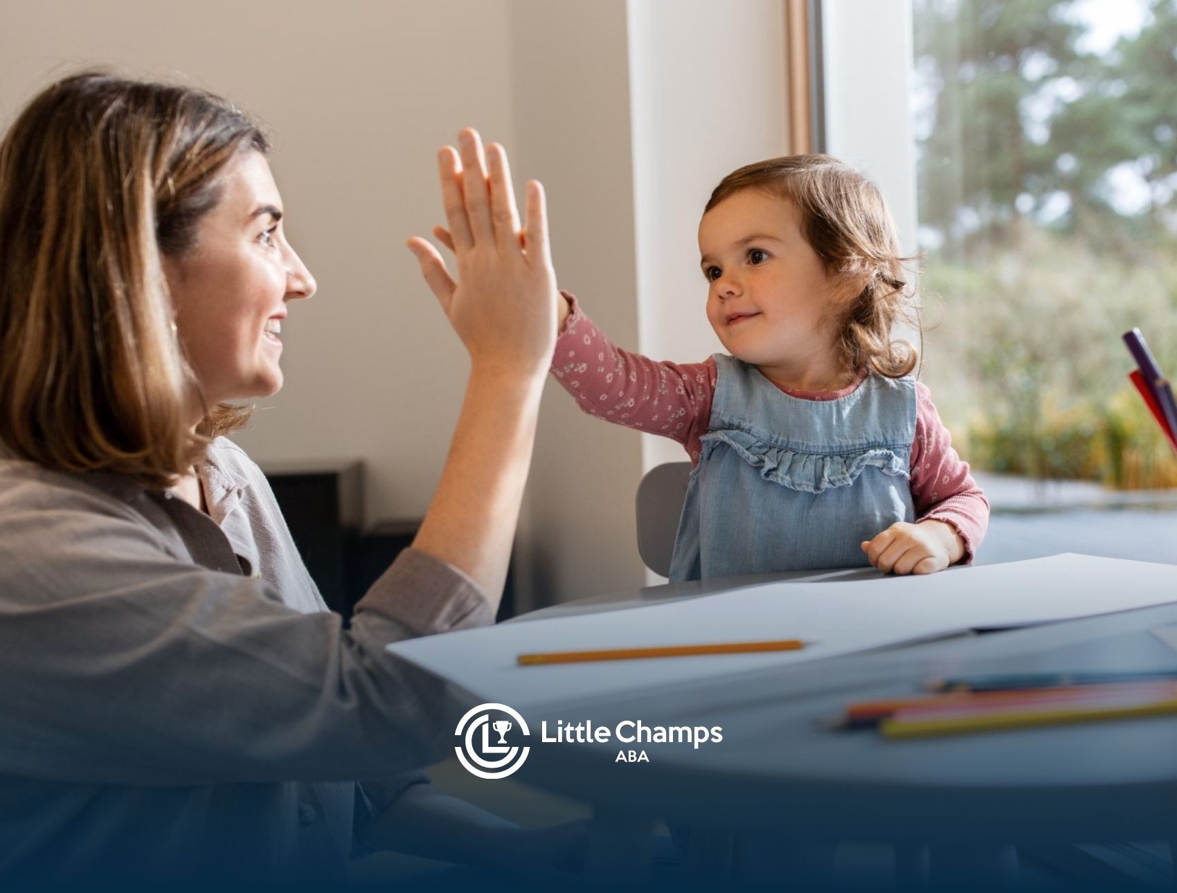 Child giving a therapist a high-five during an in-home ABA therapy session.
