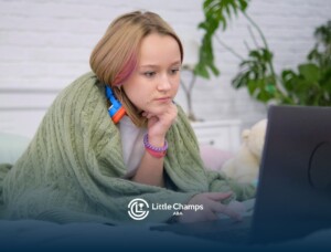 Autistic child using a laptop while resting in bed.
