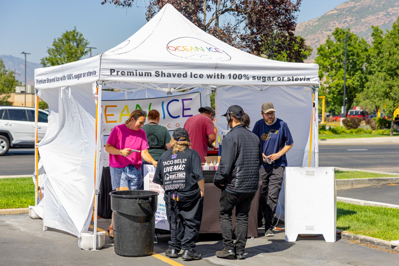 Guests visiting the shaved ice stand at the Cottonwood Heights opening.