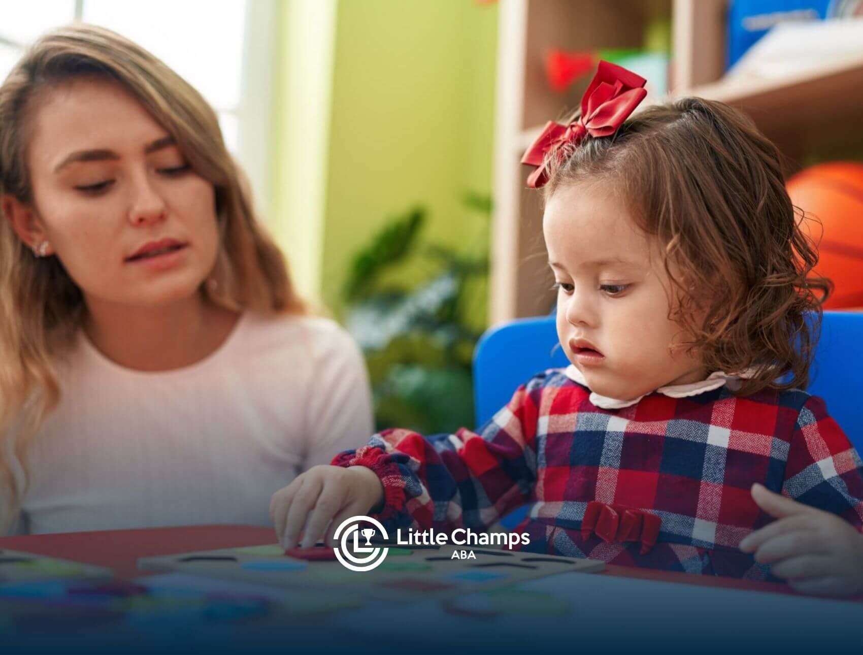 BCBA works with a young autistic child during an ABA therapy activity.