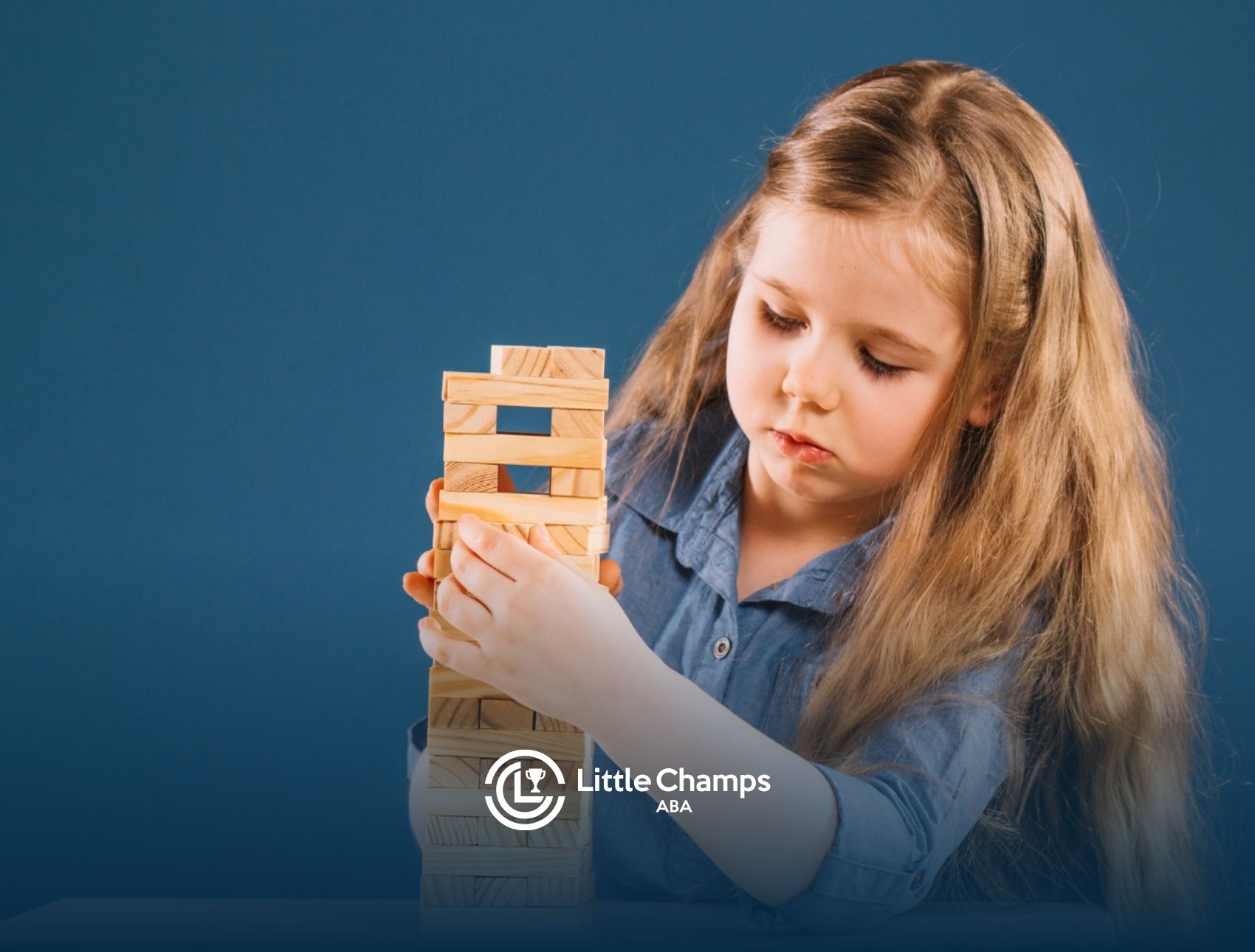 Child with autism building with wooden blocks during a focused ABA therapy activity.