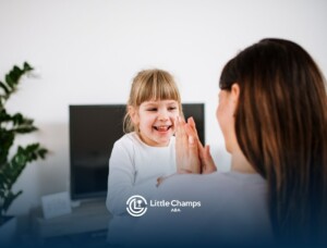 Child with autism giving a BCBA a high five during an in-home ABA therapy session.
