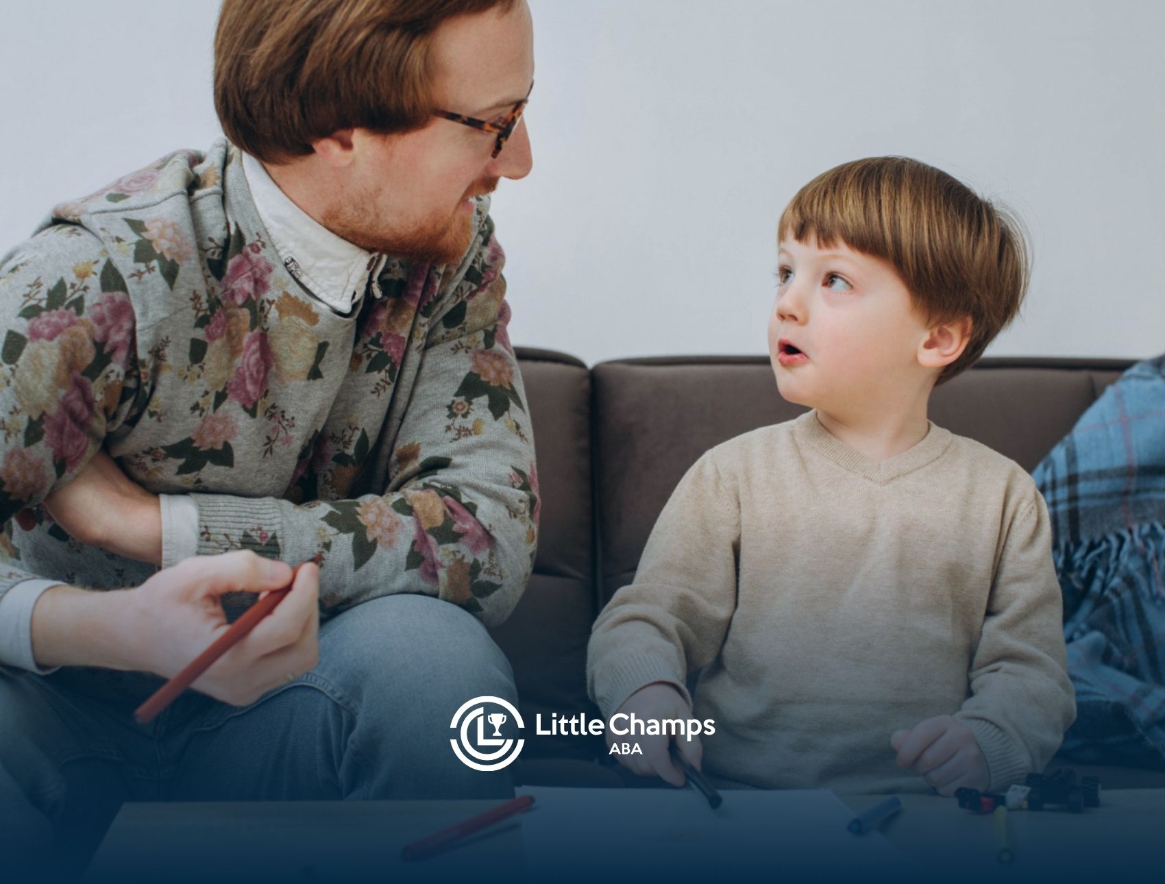BCBA and young child talking during an ABA therapy activity.