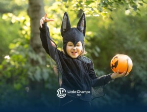 Child with autism dressed for Halloween holding a pumpkin bucket.