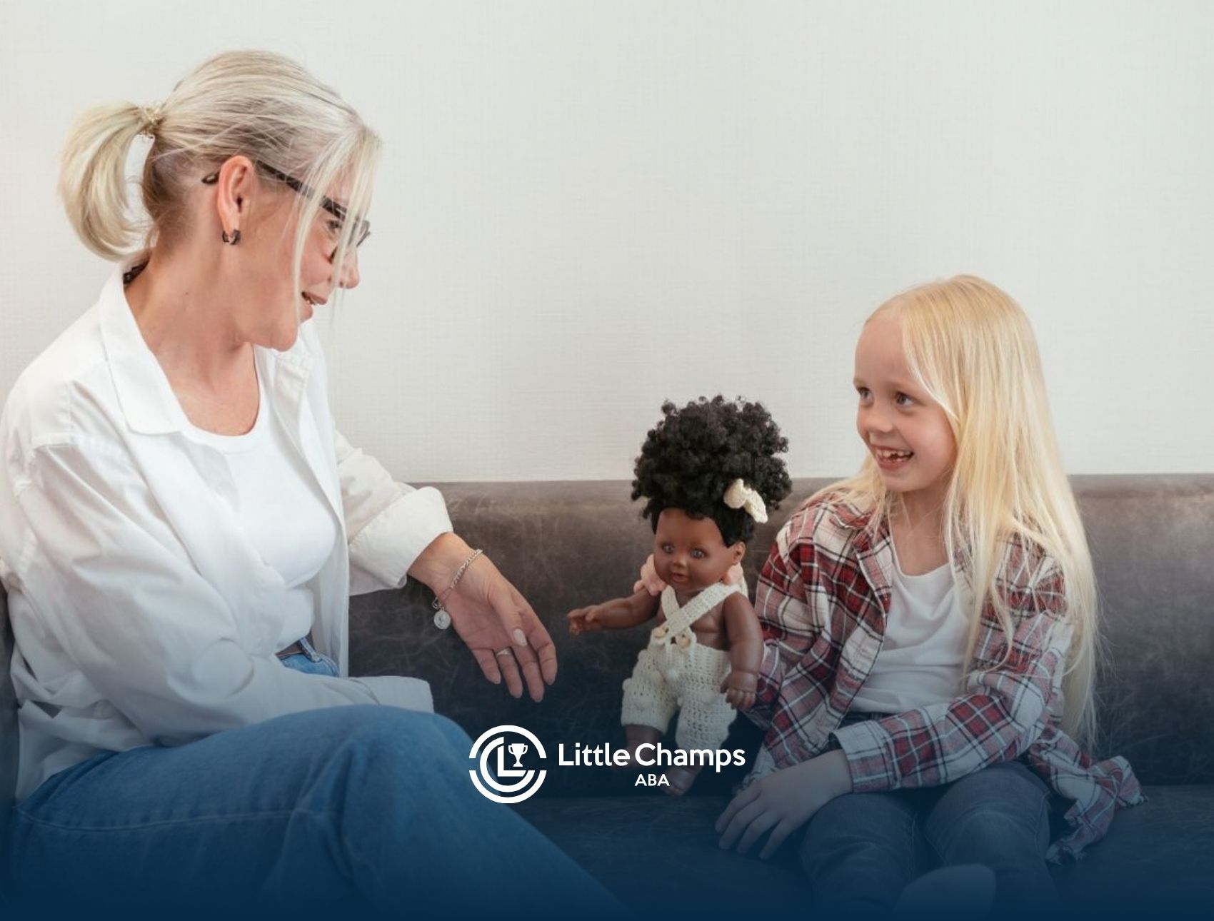 1. ABA therapist engaging a young girl in play-based learning with a doll.