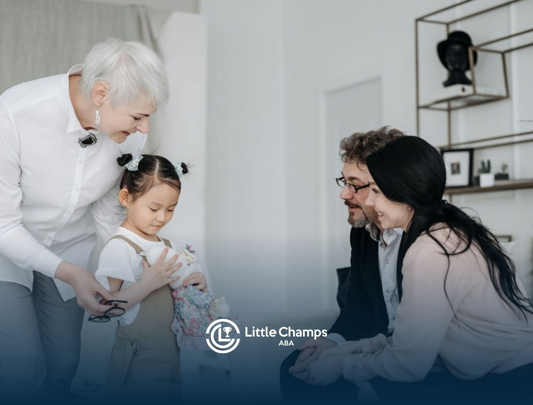 ABA therapist supporting a child while speaking with her parents during an in-home session.