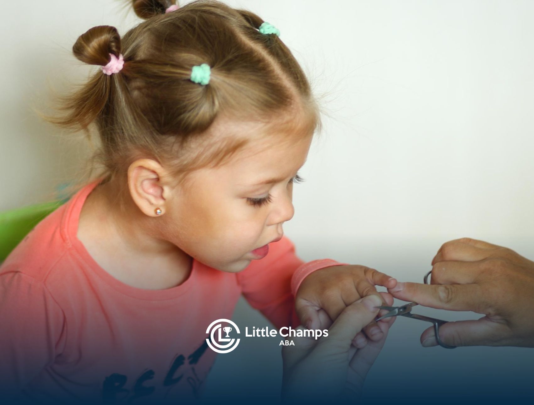 A young girl with autism watches closely as an adult gently trims her fingernails with nail scissors.