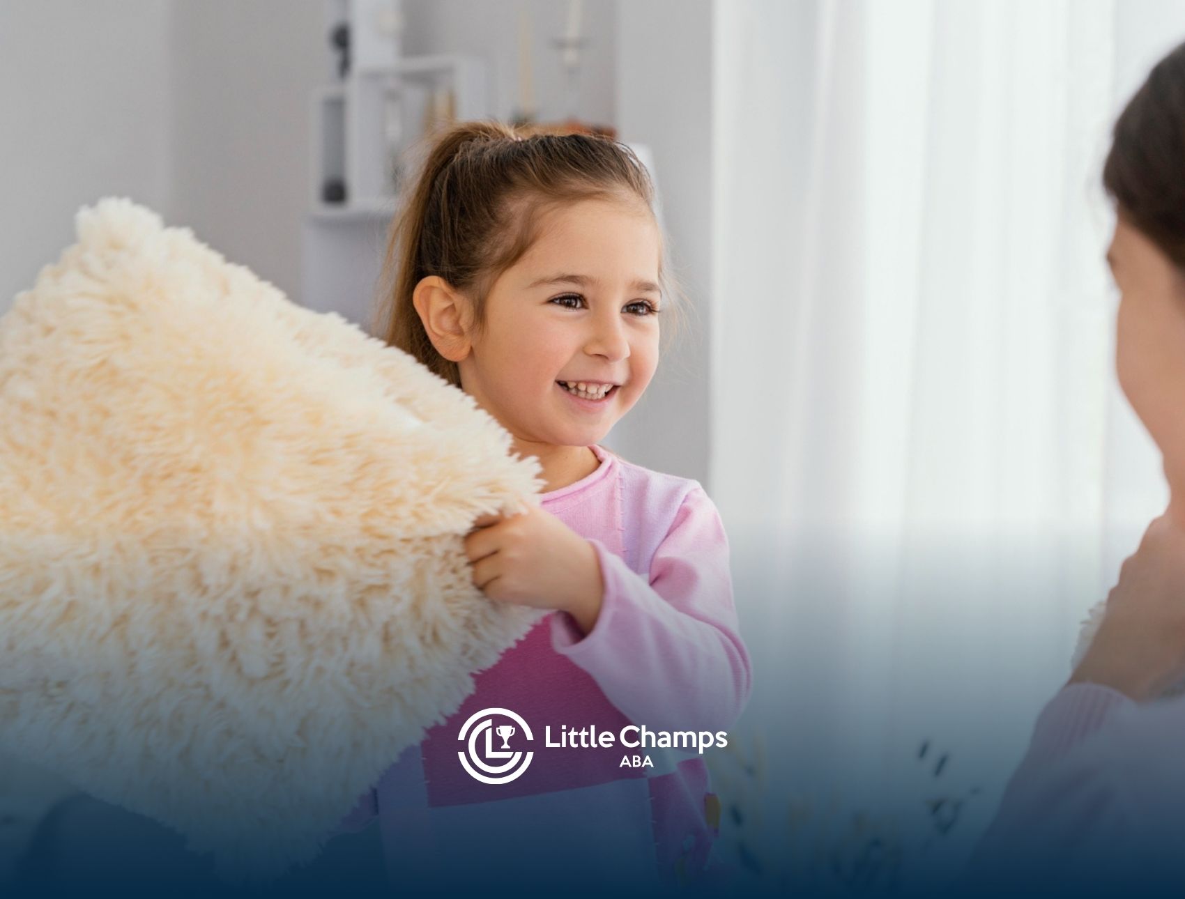 Young girl holding a soft pillow while smiling during a therapy session.